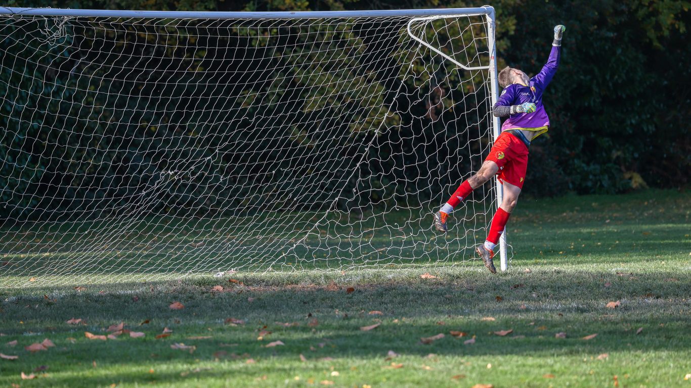 Goalkeeper jumping to save a soccer ball.