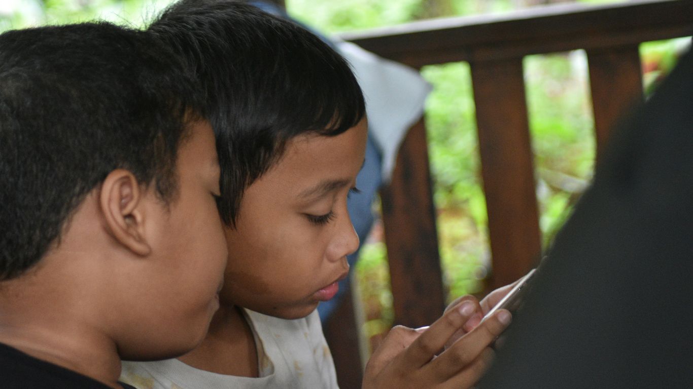 boy in white shirt holding black textile