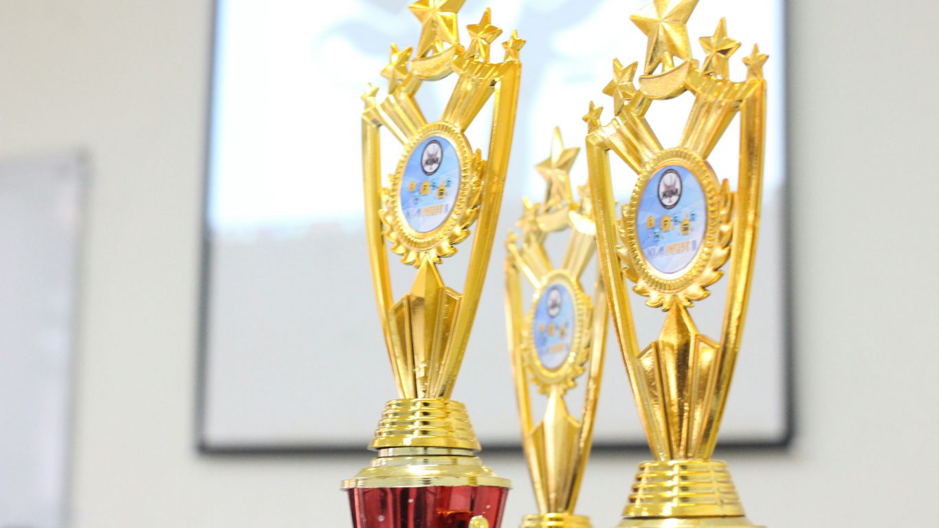 two red and gold trophies sitting on top of a table