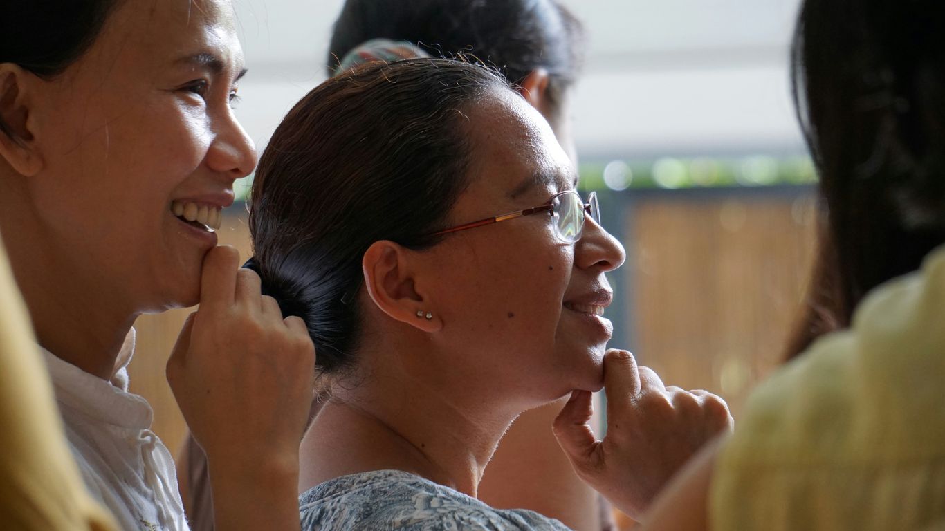 woman in white shirt wearing eyeglasses smiling