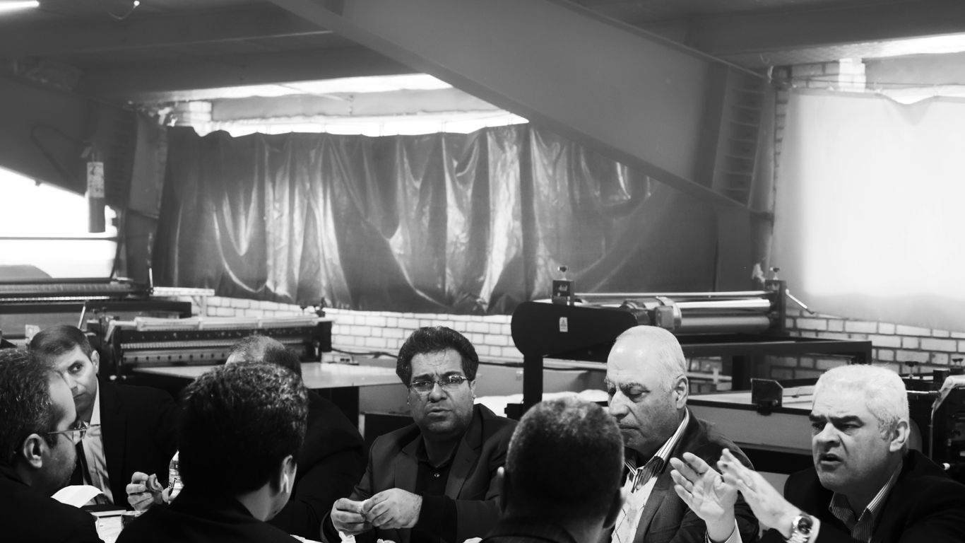 grayscale photography of group of person sitting indoors