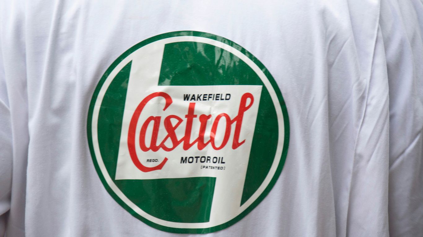 a close up of a person wearing a white shirt with a green and red logo