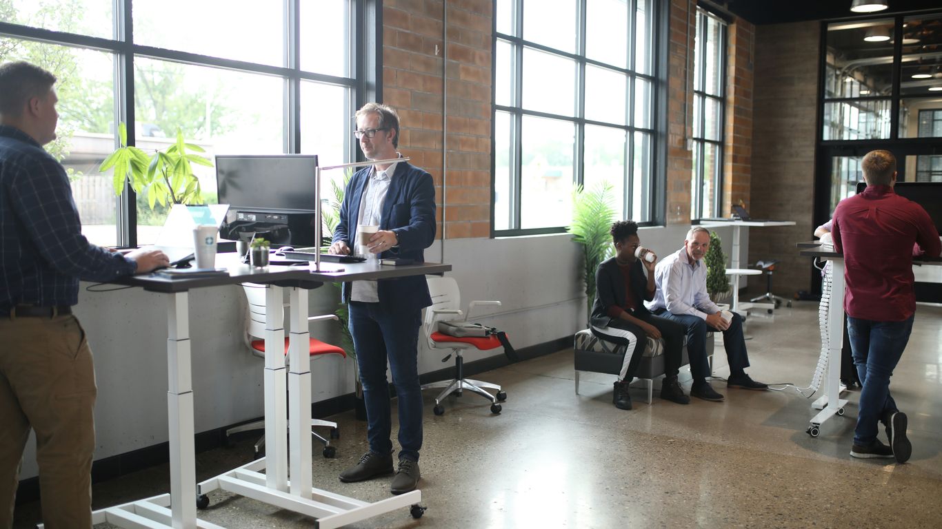 a group of people standing around a desk