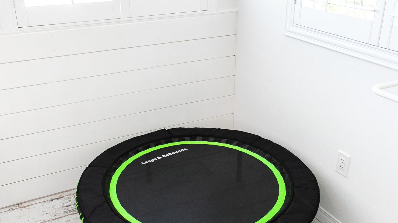 Small trampoline in a bright, white room with windows.