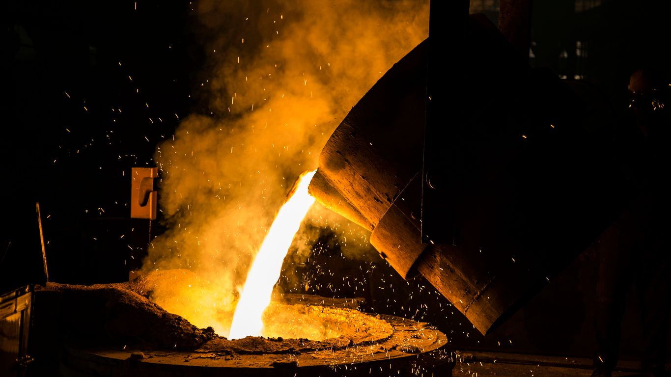 a man working on a piece of metal in a factory
