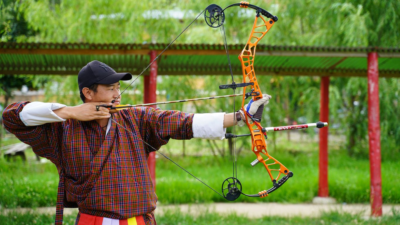 a man is holding a bow and aiming it