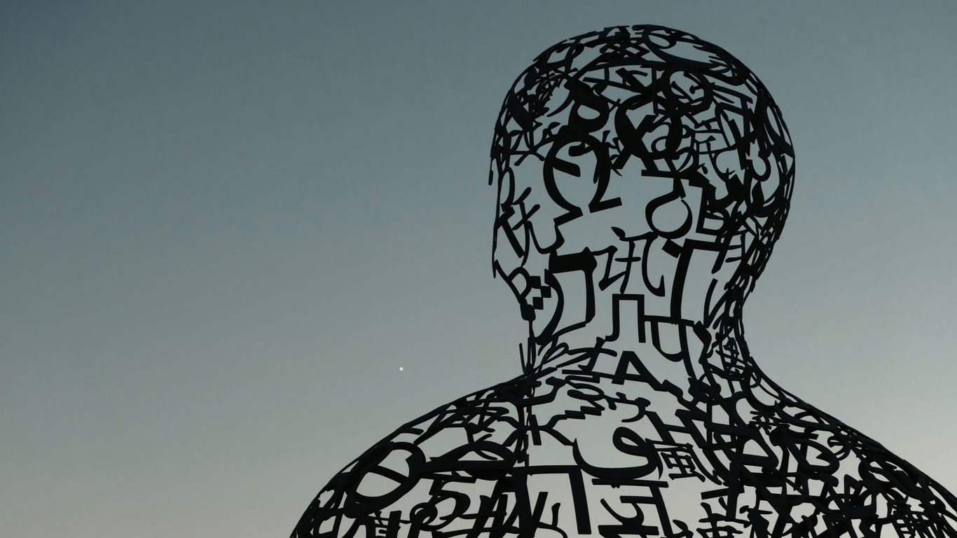 a sculpture of a man with letters all over it