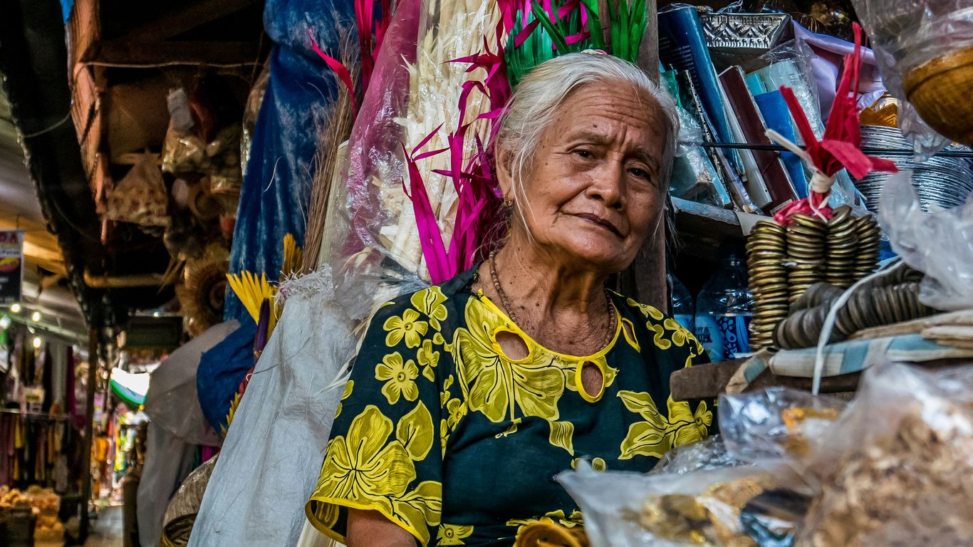 woman wearing green and yellow dress selling goods