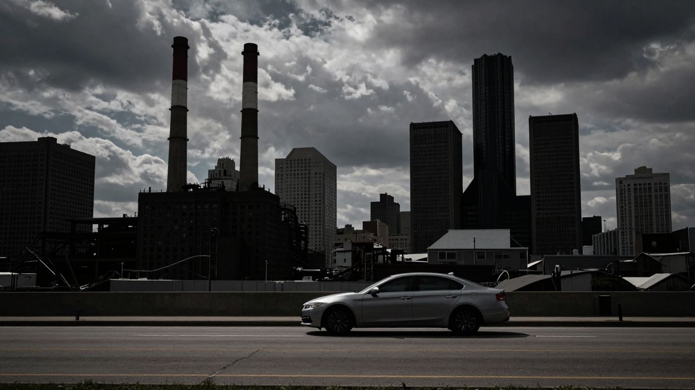 Detroit cityscape with factories and a car.