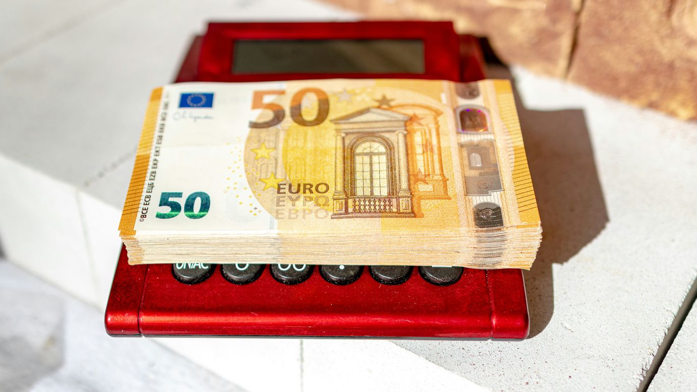 a 50 euro bill sitting on top of a red machine