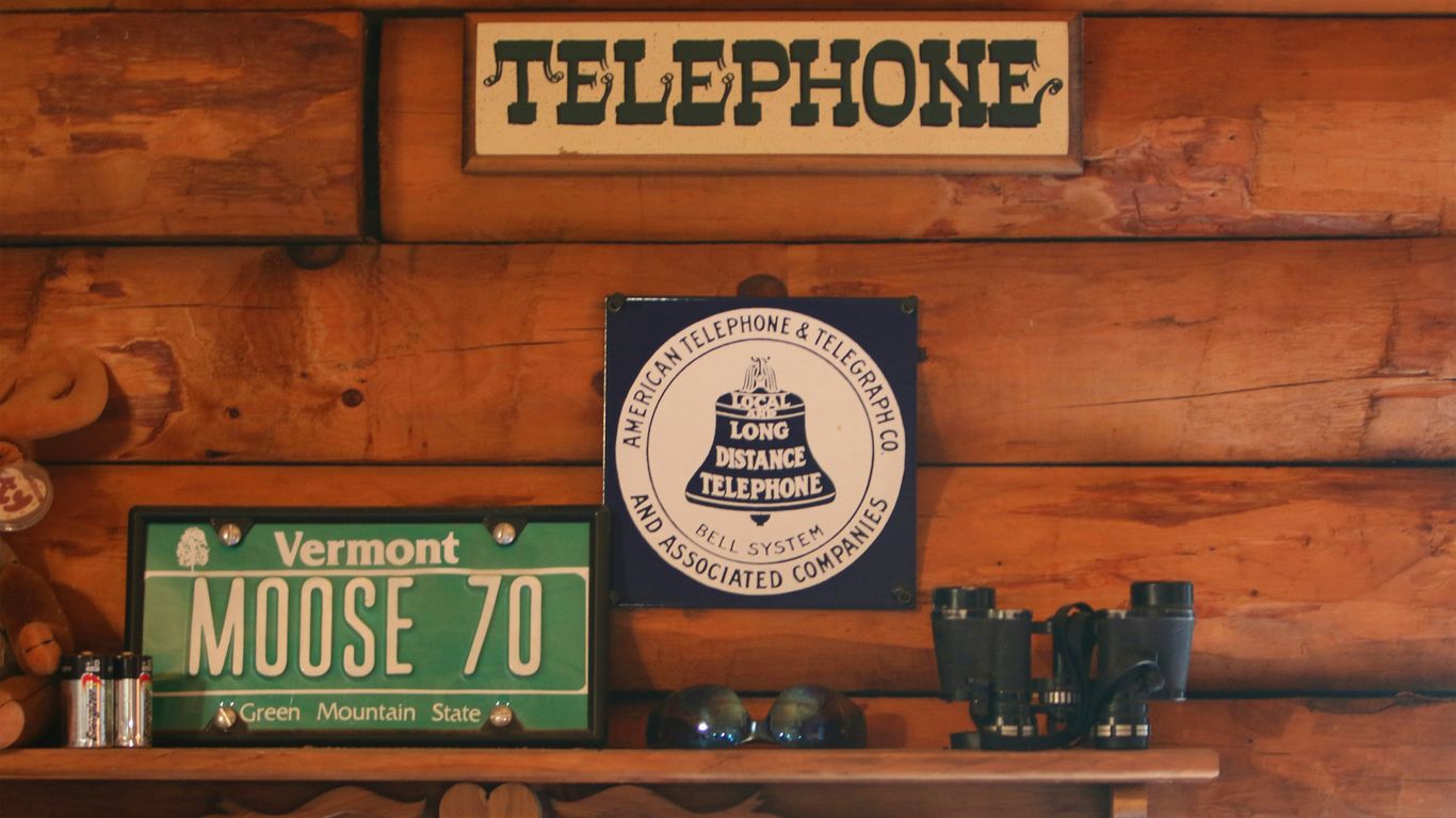a wooden wall with a sign and a phone on it