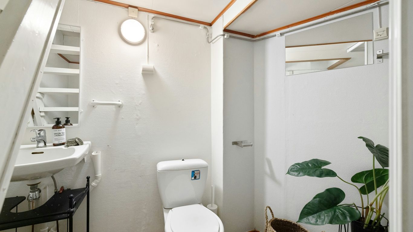 A bathroom with a toilet, sink, and stairs