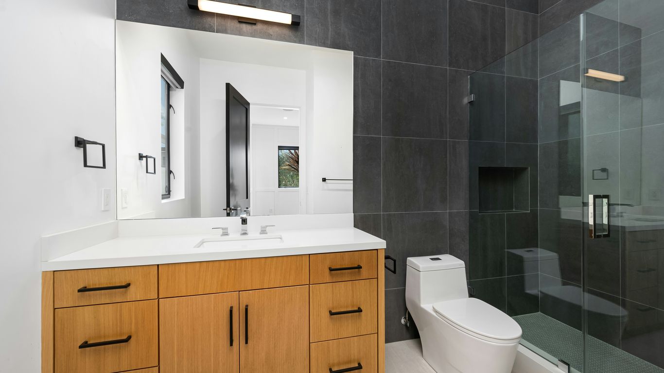 A bathroom with a toilet, sink, and shower