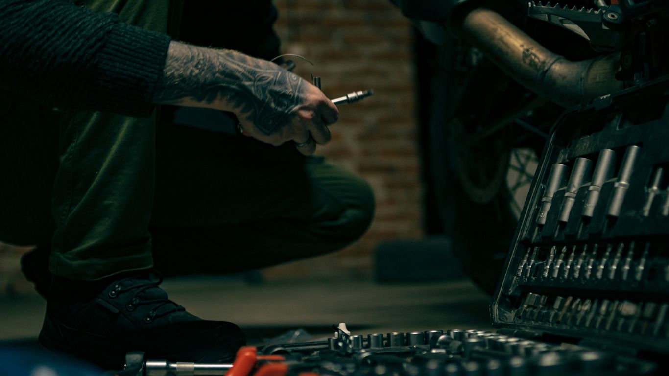 a man sitting on the ground with a cigarette in his hand