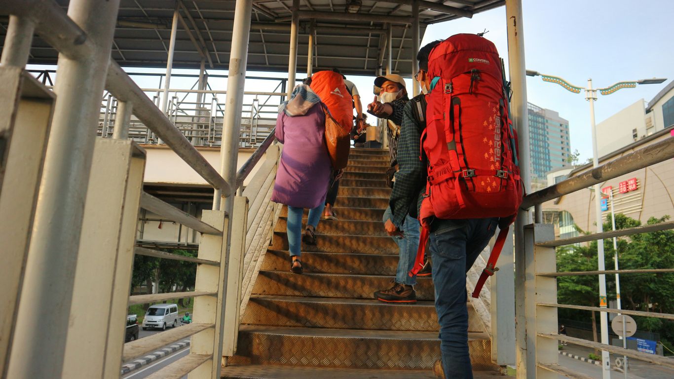 People are walking up stairs with heavy backpacks.