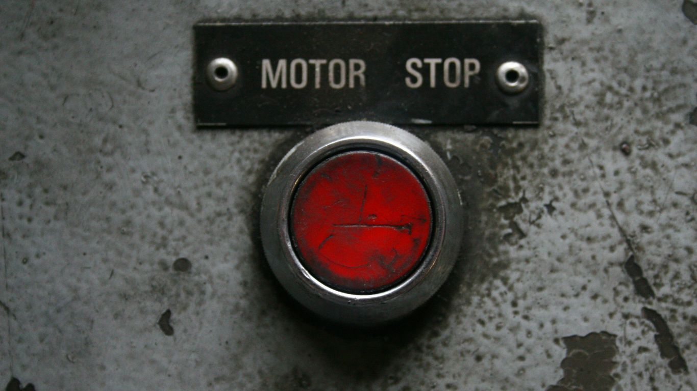 Red motor stop button on a metal panel