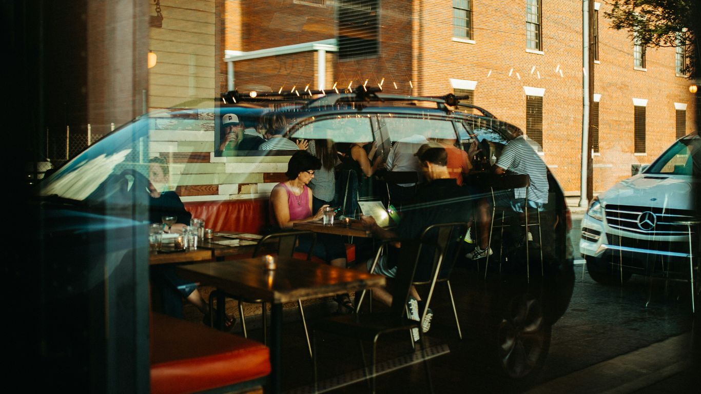 Street view into a restaurant dining room at dusk
