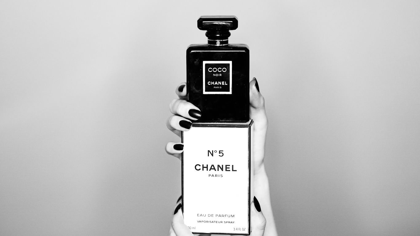 a woman holding a bottle of chanel no 5