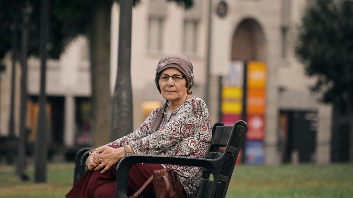 A woman sitting on a bench in a park