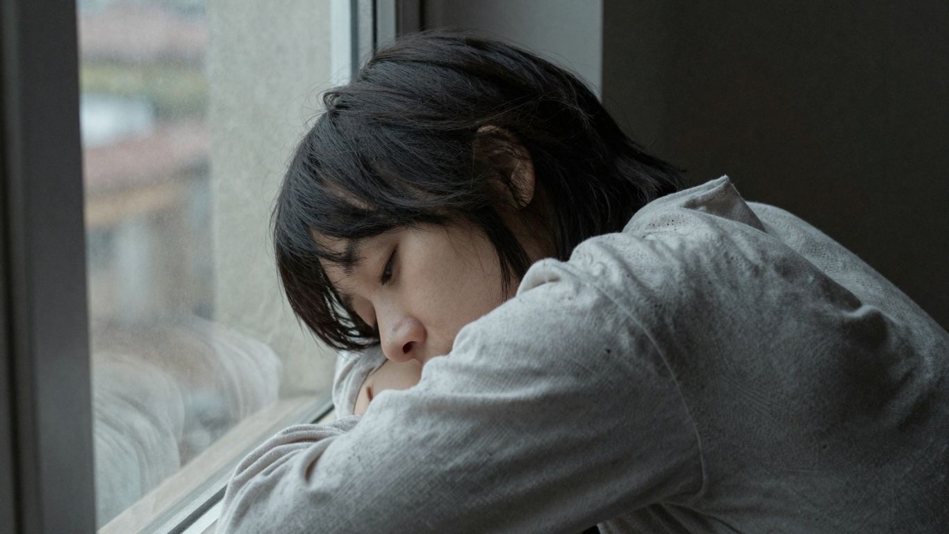 Pessoa em luto, refletindo sobre a perda.