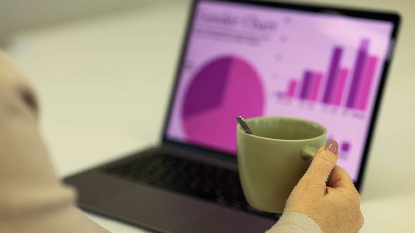 Person working on a laptop with a cup of coffee.