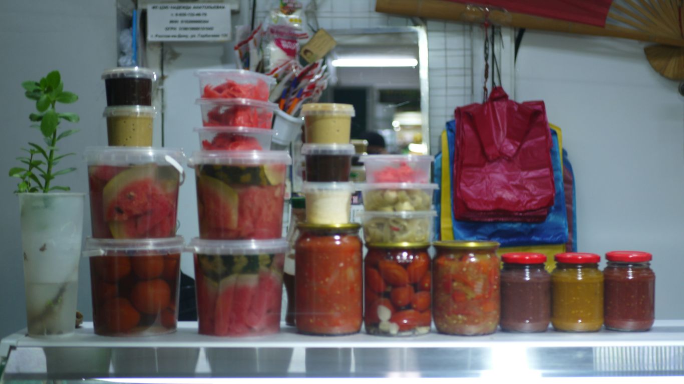 Jars and containers of preserved food on a shelf.