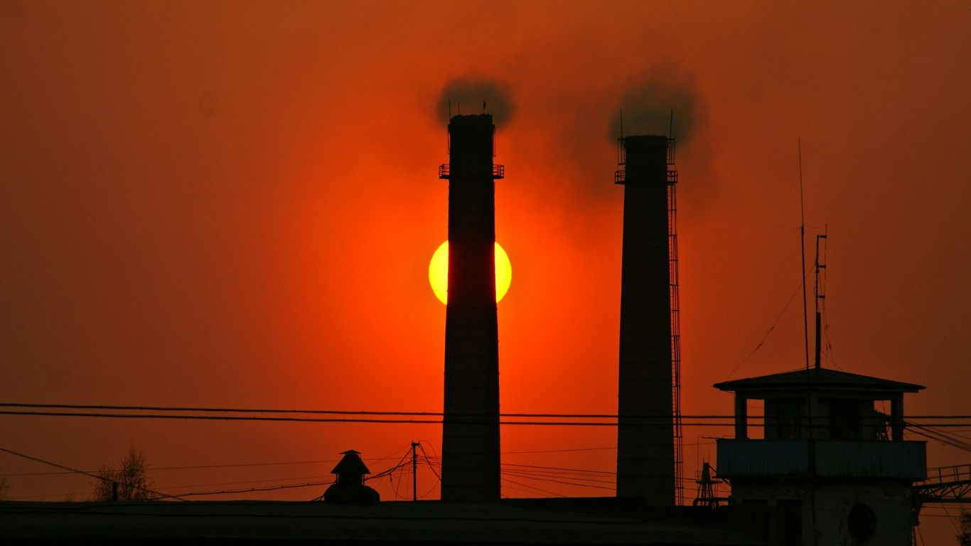 silhouette of people walking on the street near the tower during sunset
