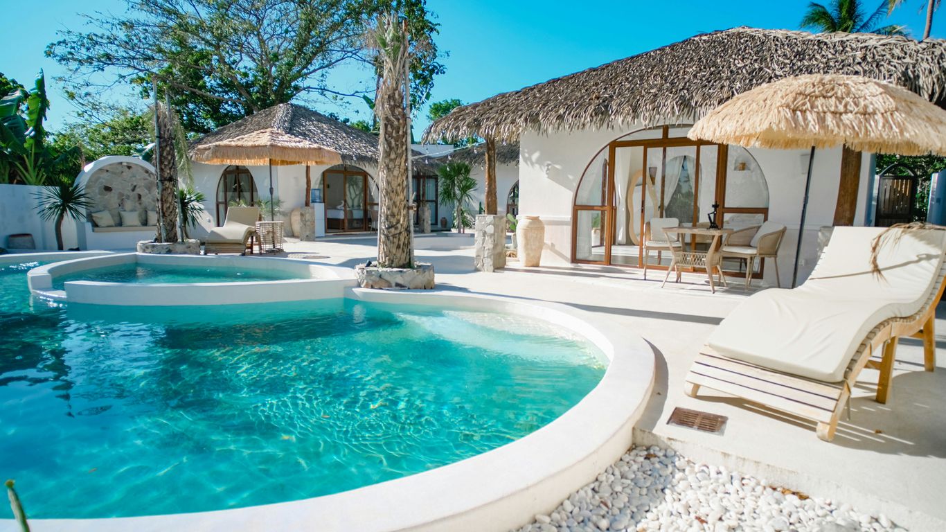 Luxury resort with pool and thatched roof bungalows