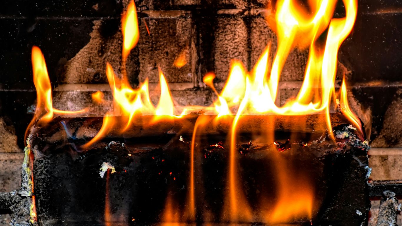 a fire burning inside of a brick oven