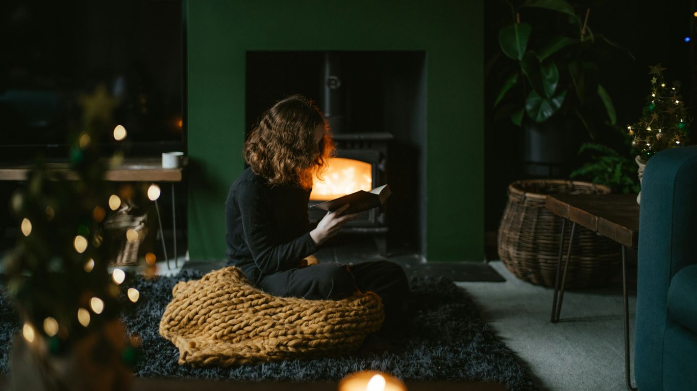 a woman sitting on the floor reading a book