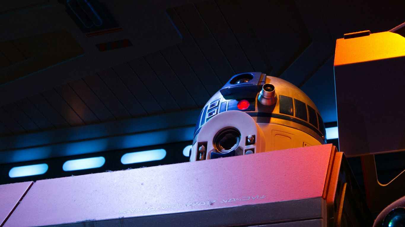 A droid with blue and white details looks forward.