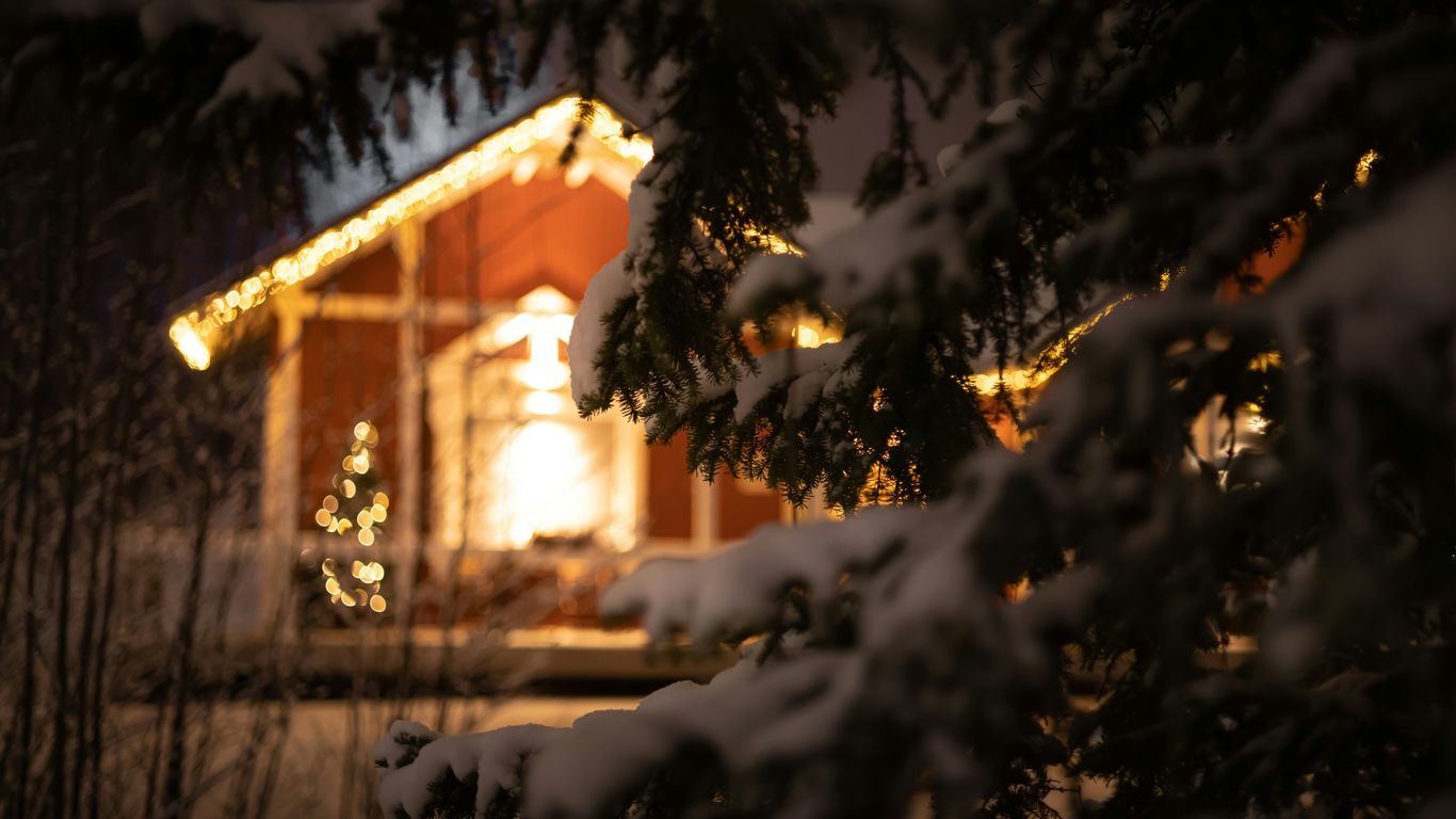a house is lit up at night in the snow