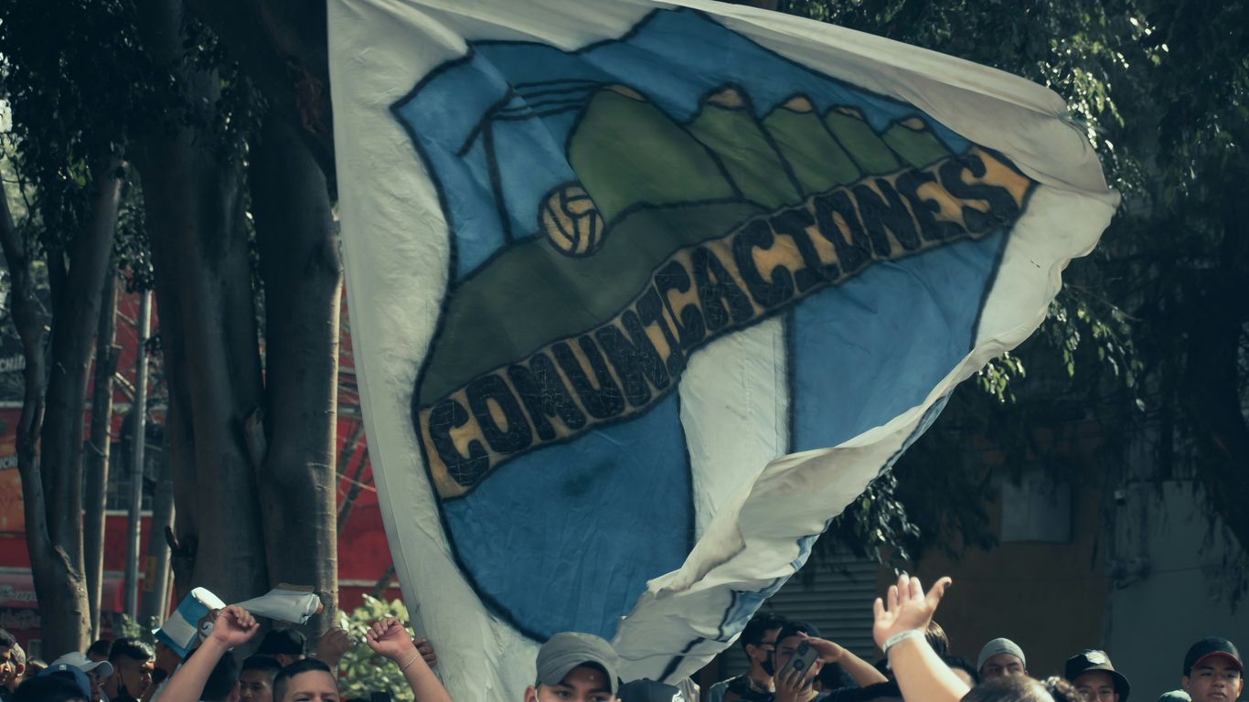 a group of people holding up a large flag