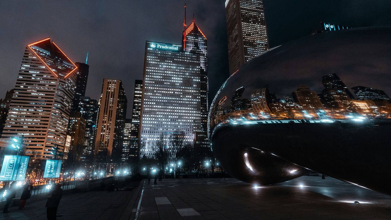 black car on road near high rise buildings during night time