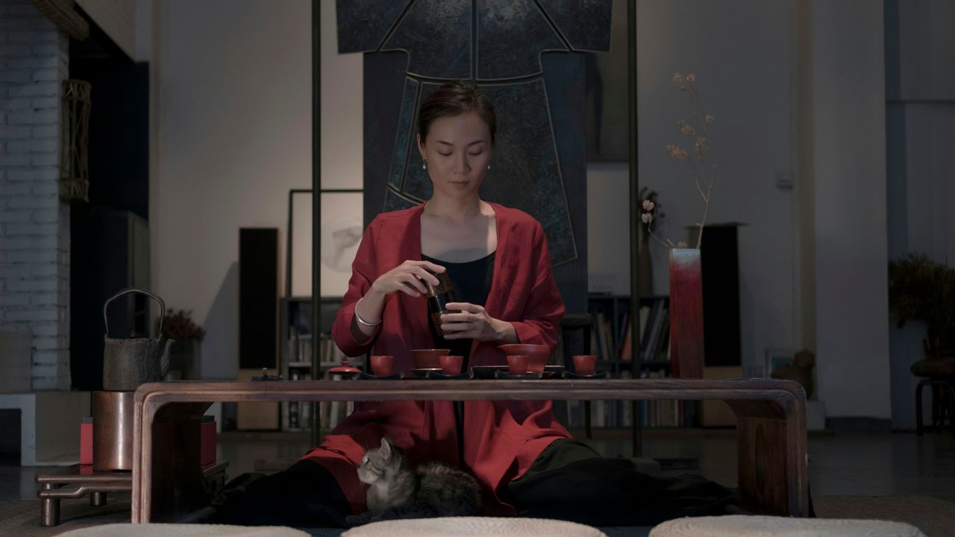 woman sitting beside table holding cup