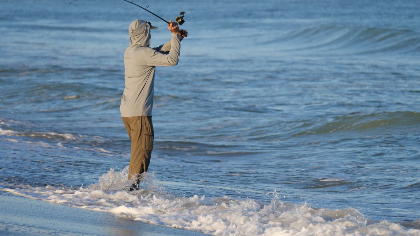 a man playing golf on the beach