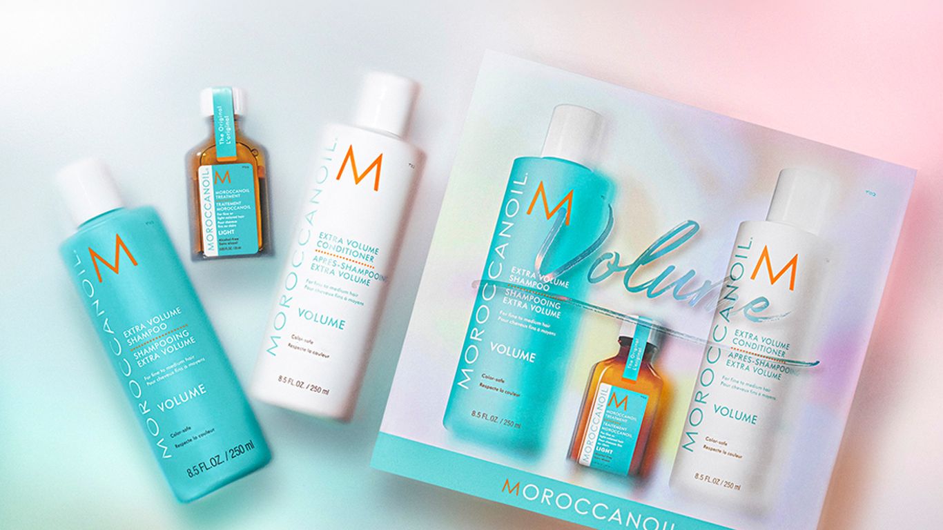 Haircare products from Moroccanoil displayed against a gradient background.