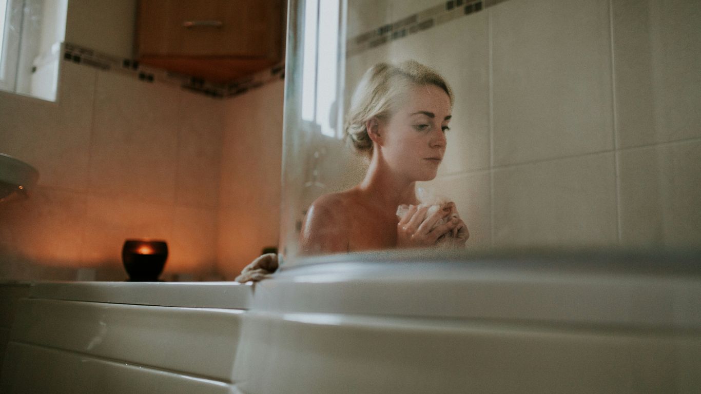naked woman sitting inside bath tub