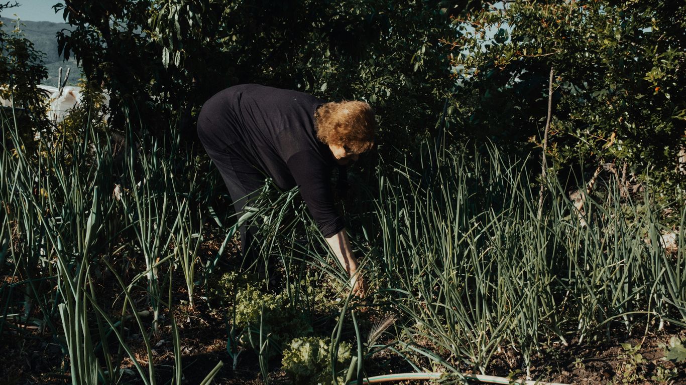 man in black long sleeve shirt and black pants standing on green grass field during daytime