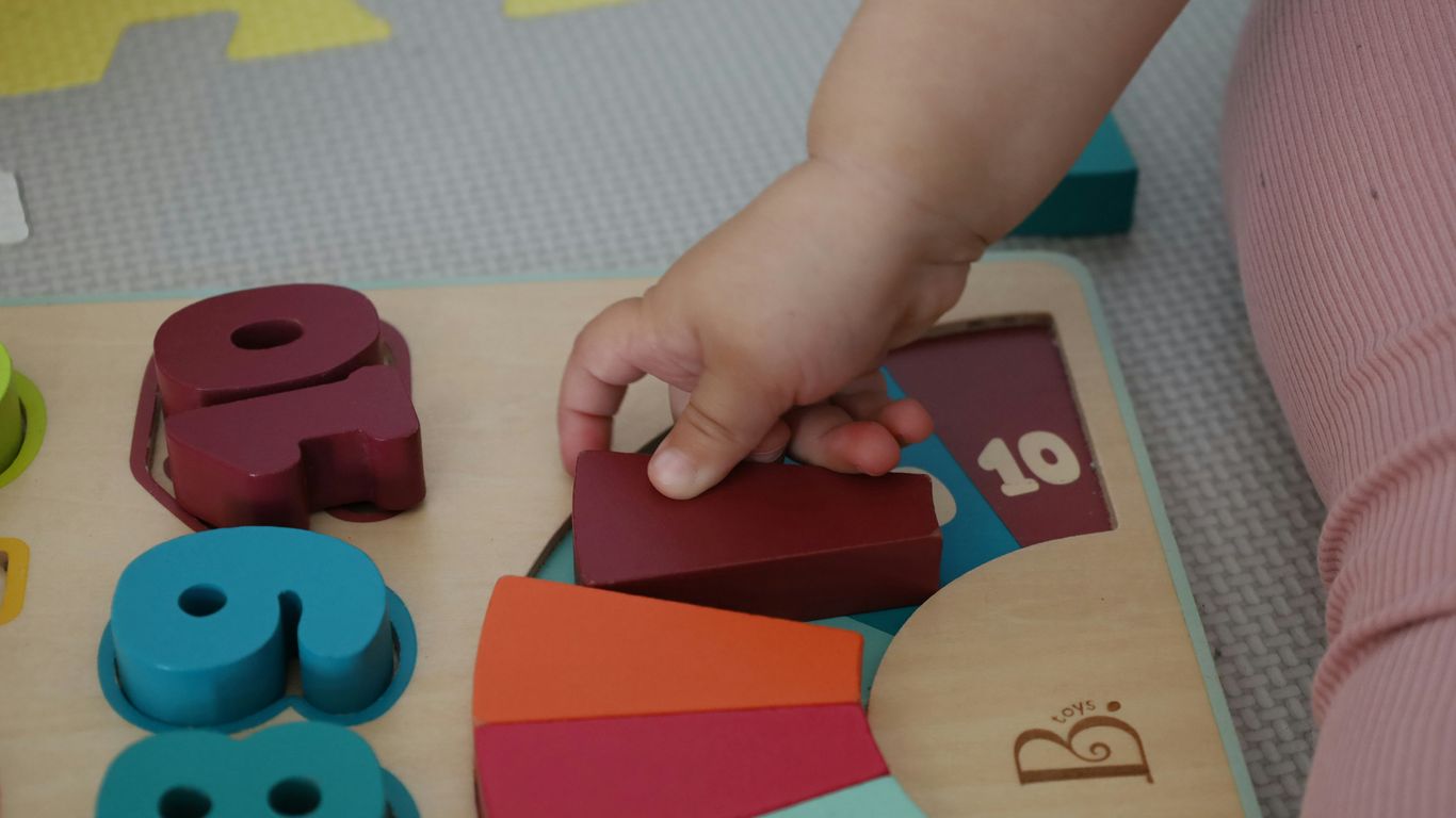 a child is playing with wooden toys on the floor