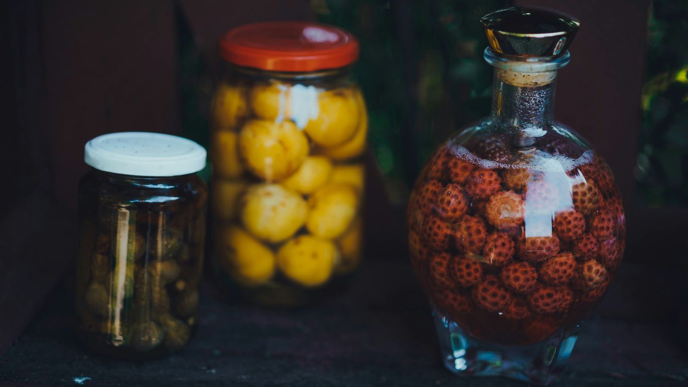 a glass bottle filled with lots of fruit