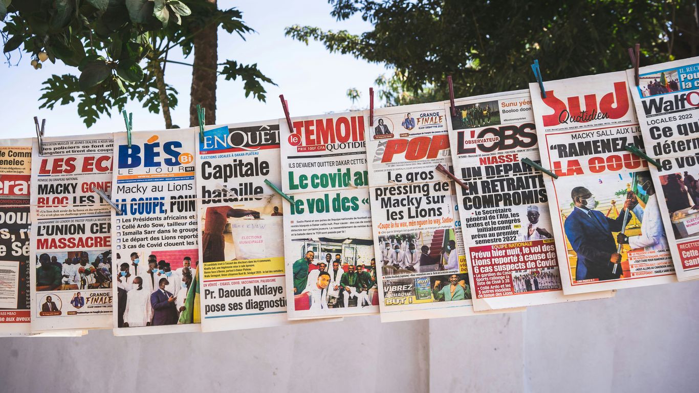 a number of newspapers on a wall with trees in the background