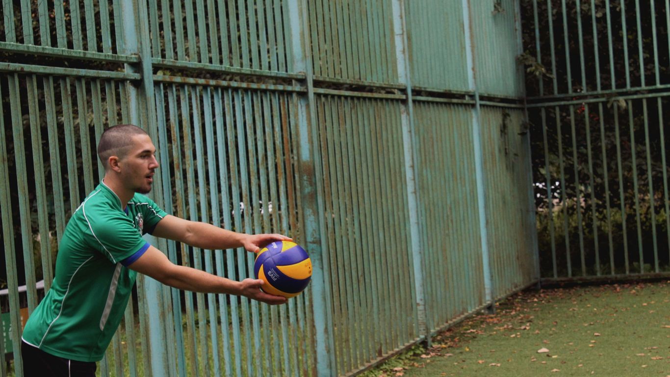 a man in a green shirt holding a soccer ball
