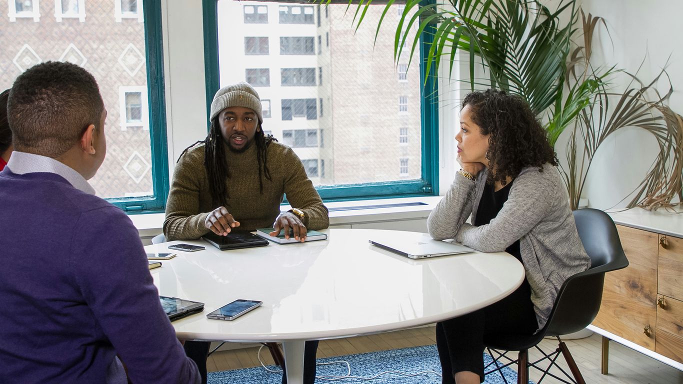 a group of people sitting around a white table