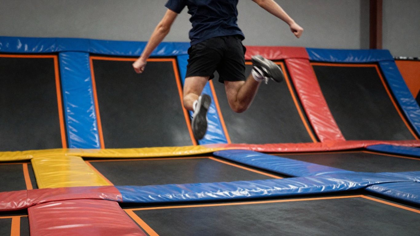 Person jumping high in a colorful trampoline park.