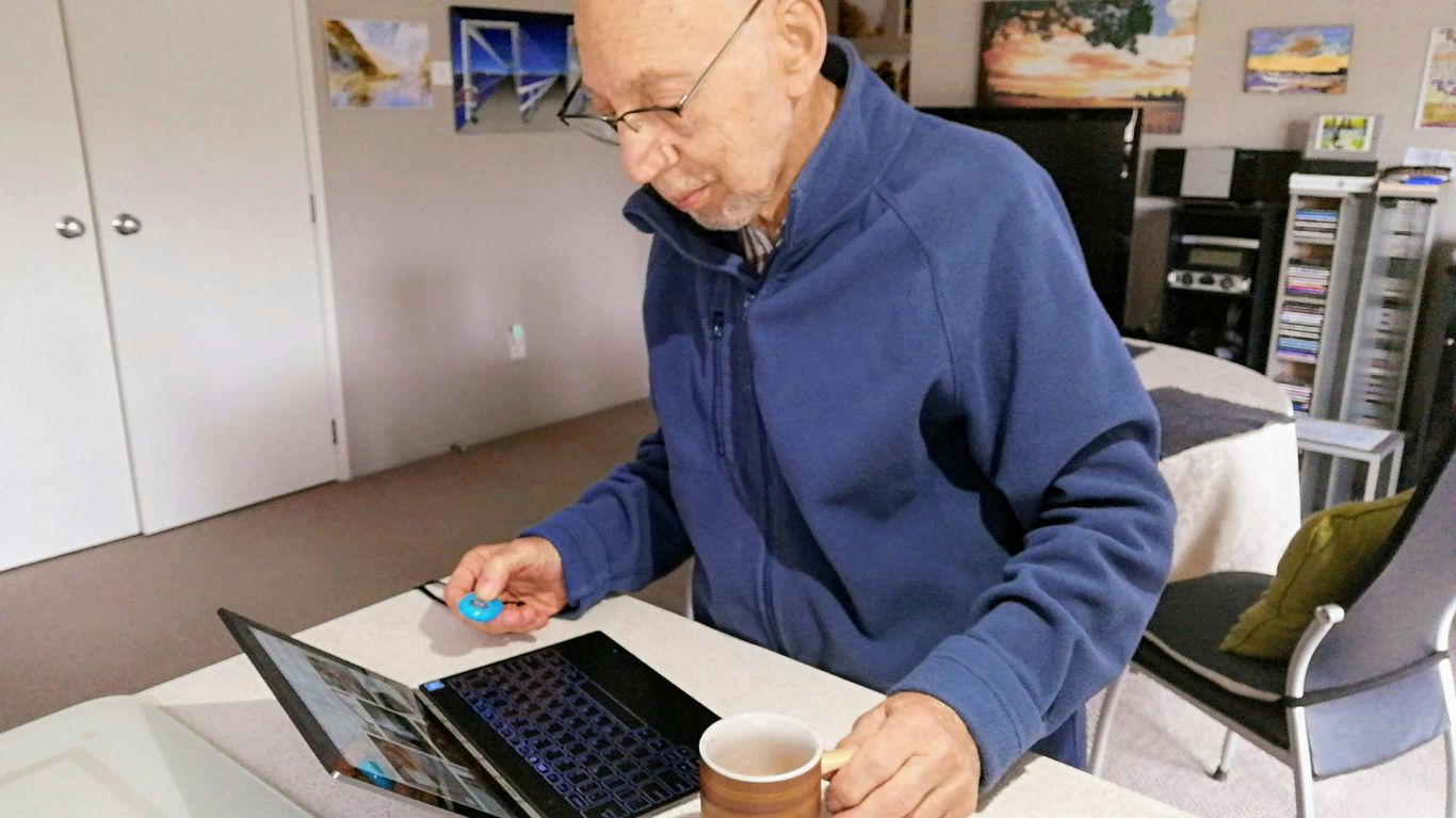 man in blue sweater using macbook pro