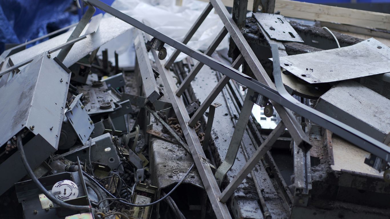 a pile of metal scrap next to a blue wall