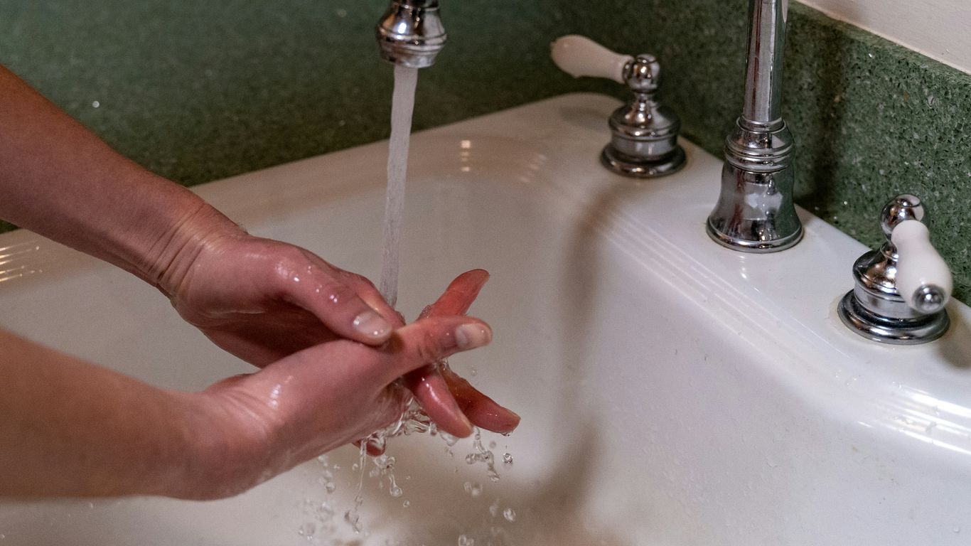 person holding stainless steel faucet