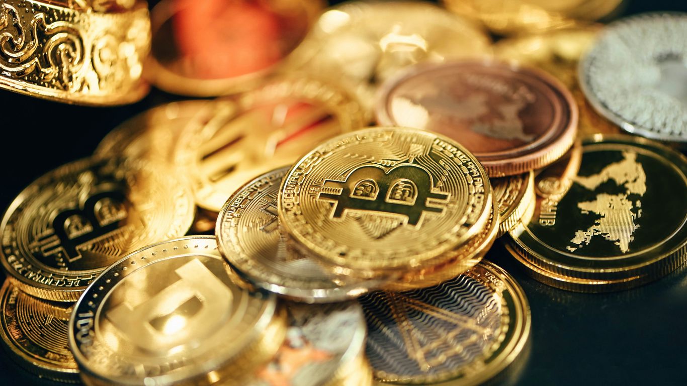 A variety of cryptocurrency coins displayed on a surface.