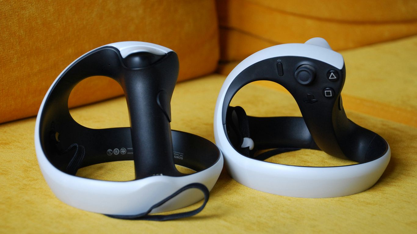 a couple of black and white controllers sitting on top of a couch